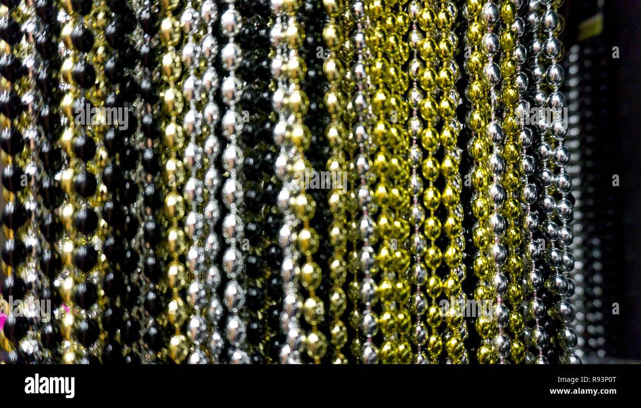 Many black, white, silver, gold and golden beads party neacklaces for New Years celebrations or background. Macro close up horizontal photo vertical neacklace Stock Photo