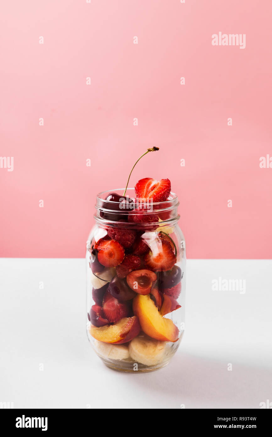 Various fruits and berries in a glass jar. Concept meals to go Stock