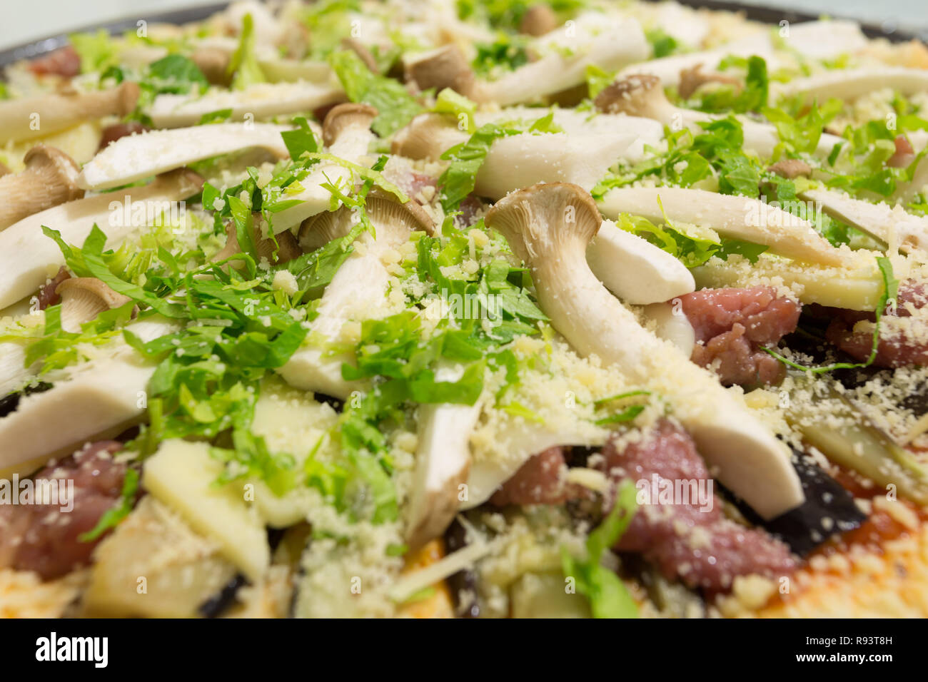 Fresh homemade pizza ready to bake, with King Trumpet mushroom