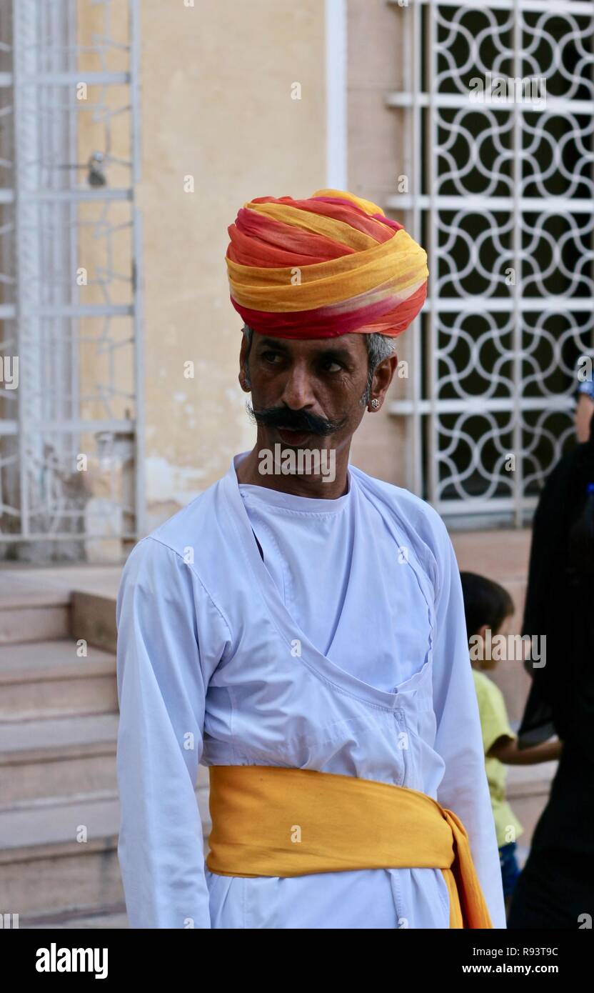 An Indian man in white with orange and yellow turban Stock Photo