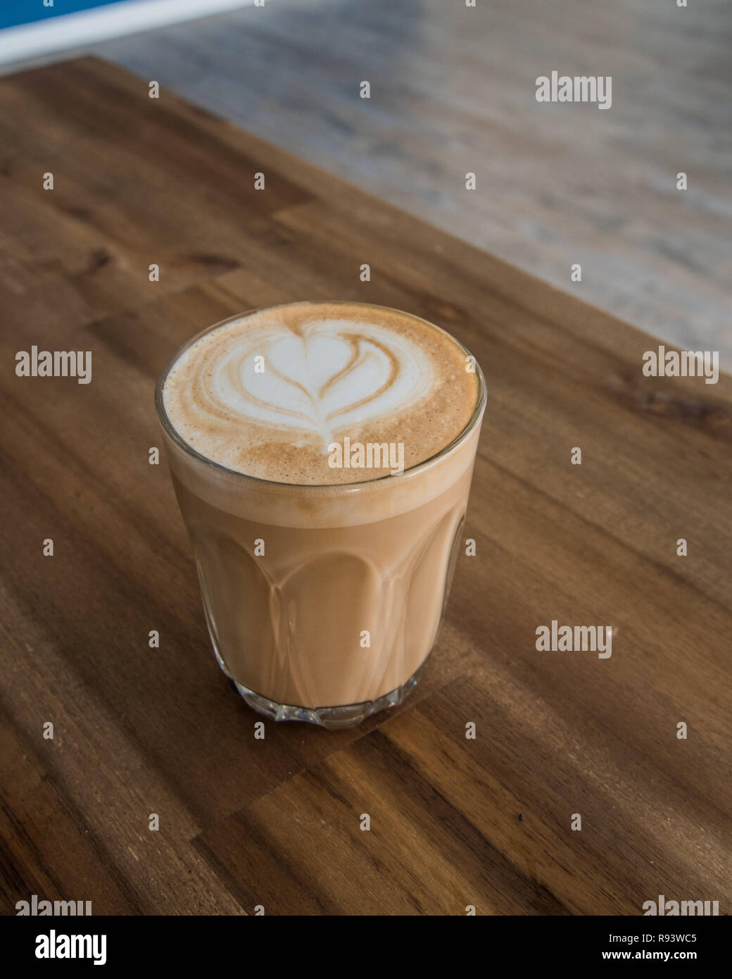 Coffee latte art on a bench with coffee machine tools around it. Cafe latte with a heart on it, beautiful warm drink Stock Photo