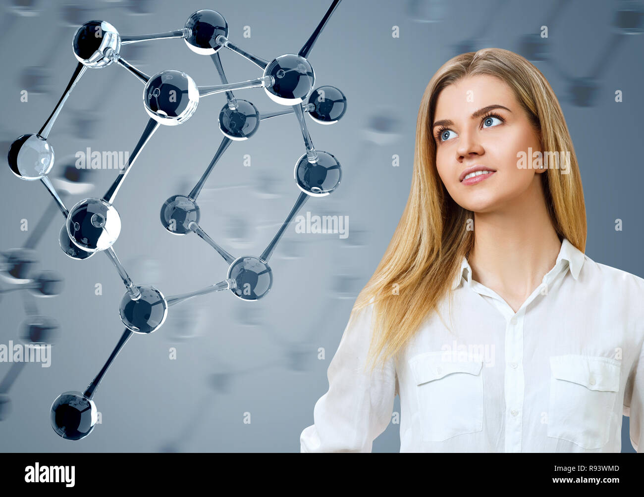 Young woman looking on glass molecules. Stock Photo