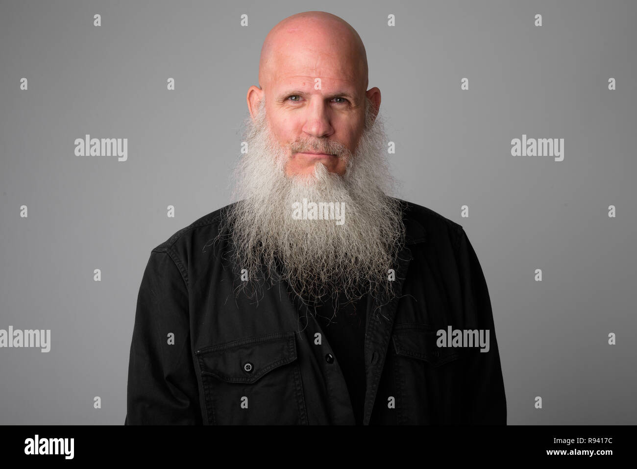 Face Of Mature Bald Man With Long Gray Beard Looking At Camera