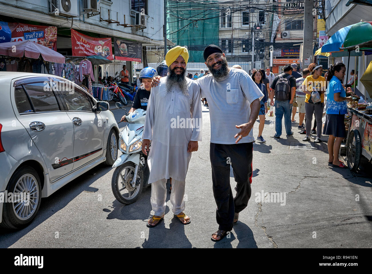Indian Sikh traditional Kurta pajama shirt and turban head wear against his western attired counterpart - modern versus traditional Stock Photo