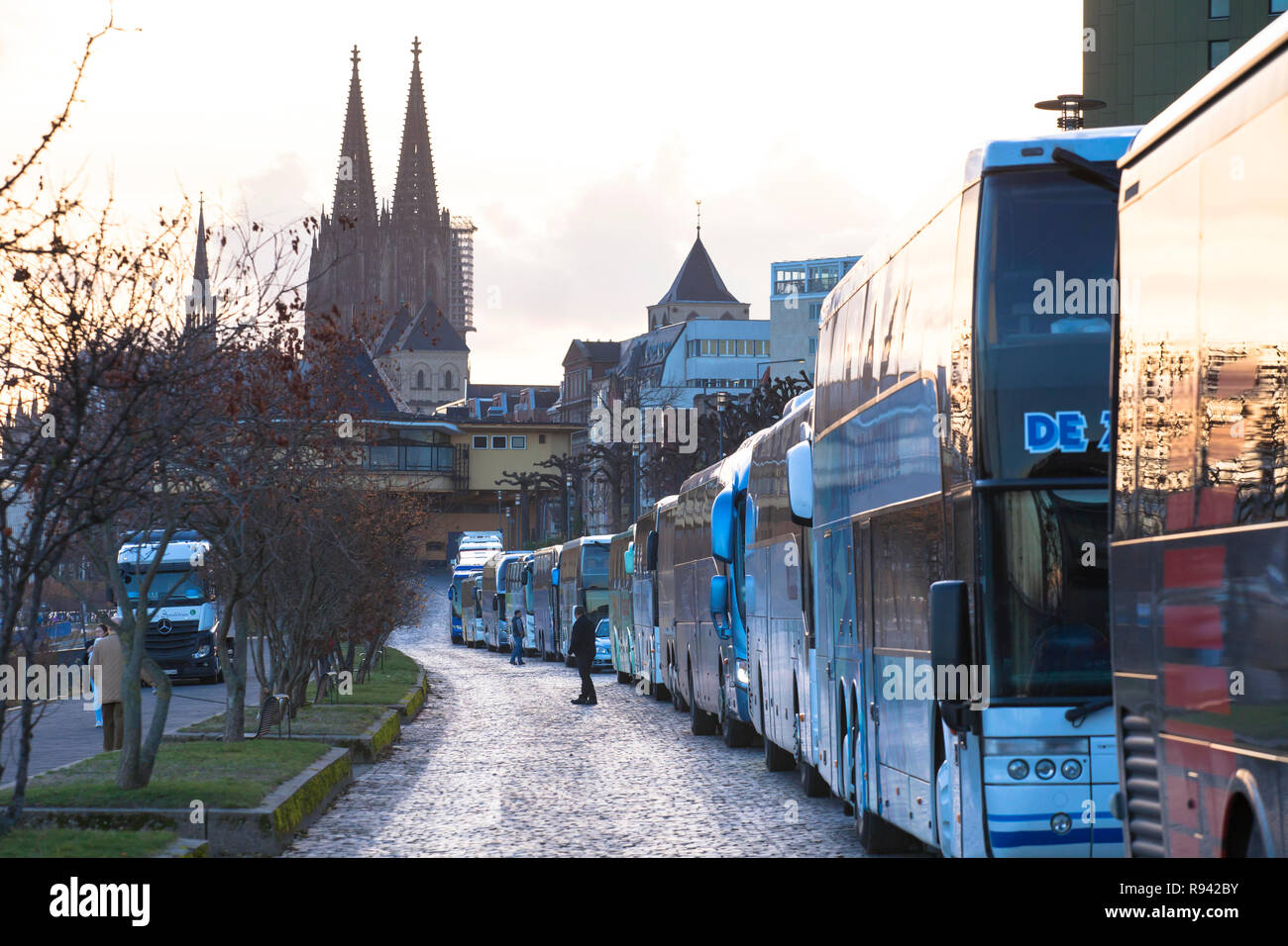coaches park in long rows at the street Konrad-Adenauer-Ufer on the river Rhine, the cathedral, Cologne, Germany.  Reisebusse parken in langen Schlang Stock Photo