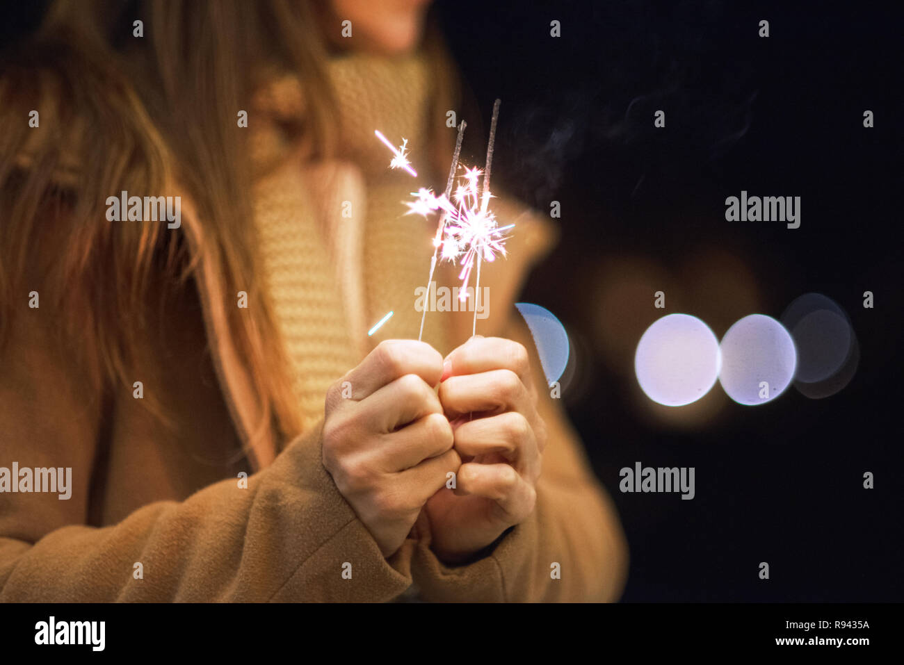 woman having fun with sparkler in her hands Stock Photo