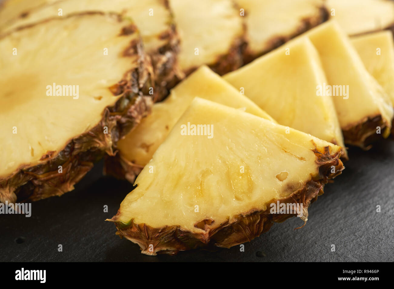Sliced fresh pineapple on a slate surface Stock Photo