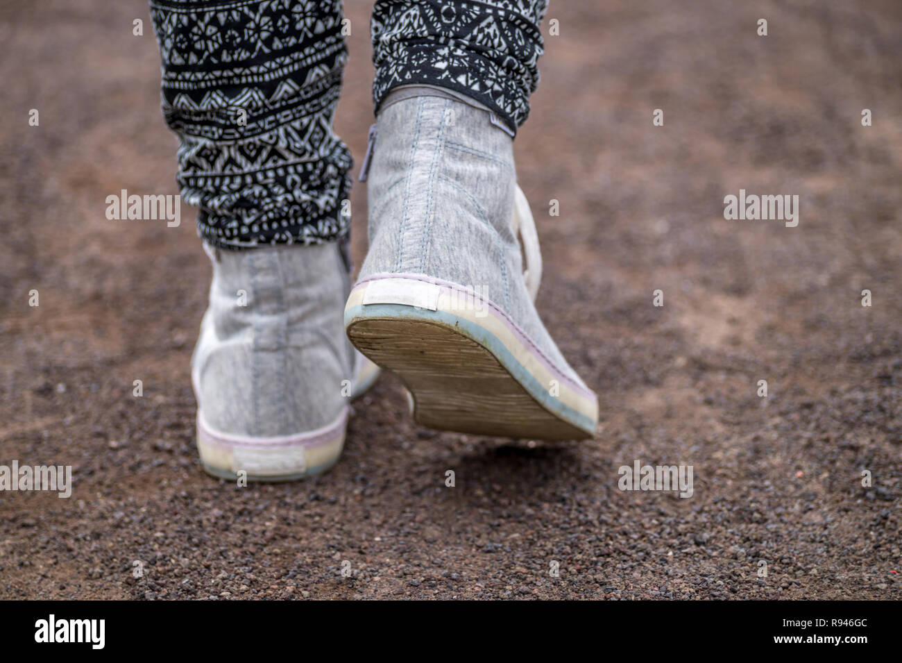 Close up of a pair of shoes. Girls feet white sneakers. Stock Photo