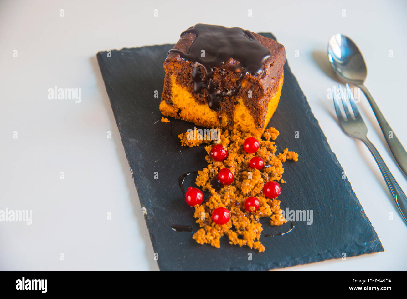 Chocolate cake with redcurrants and biscuit powder. Stock Photo