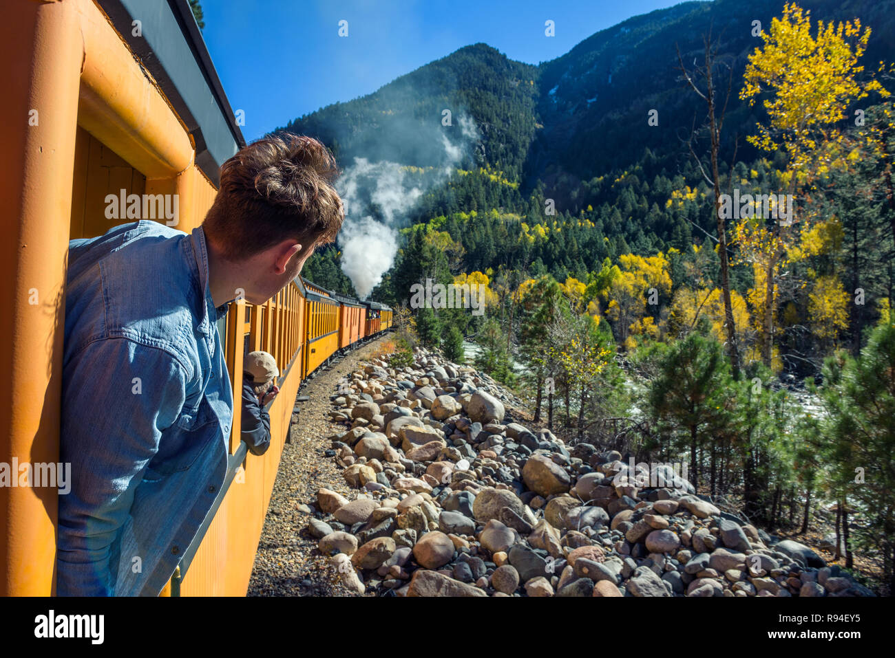 Young man looking out of train window Stock Photo