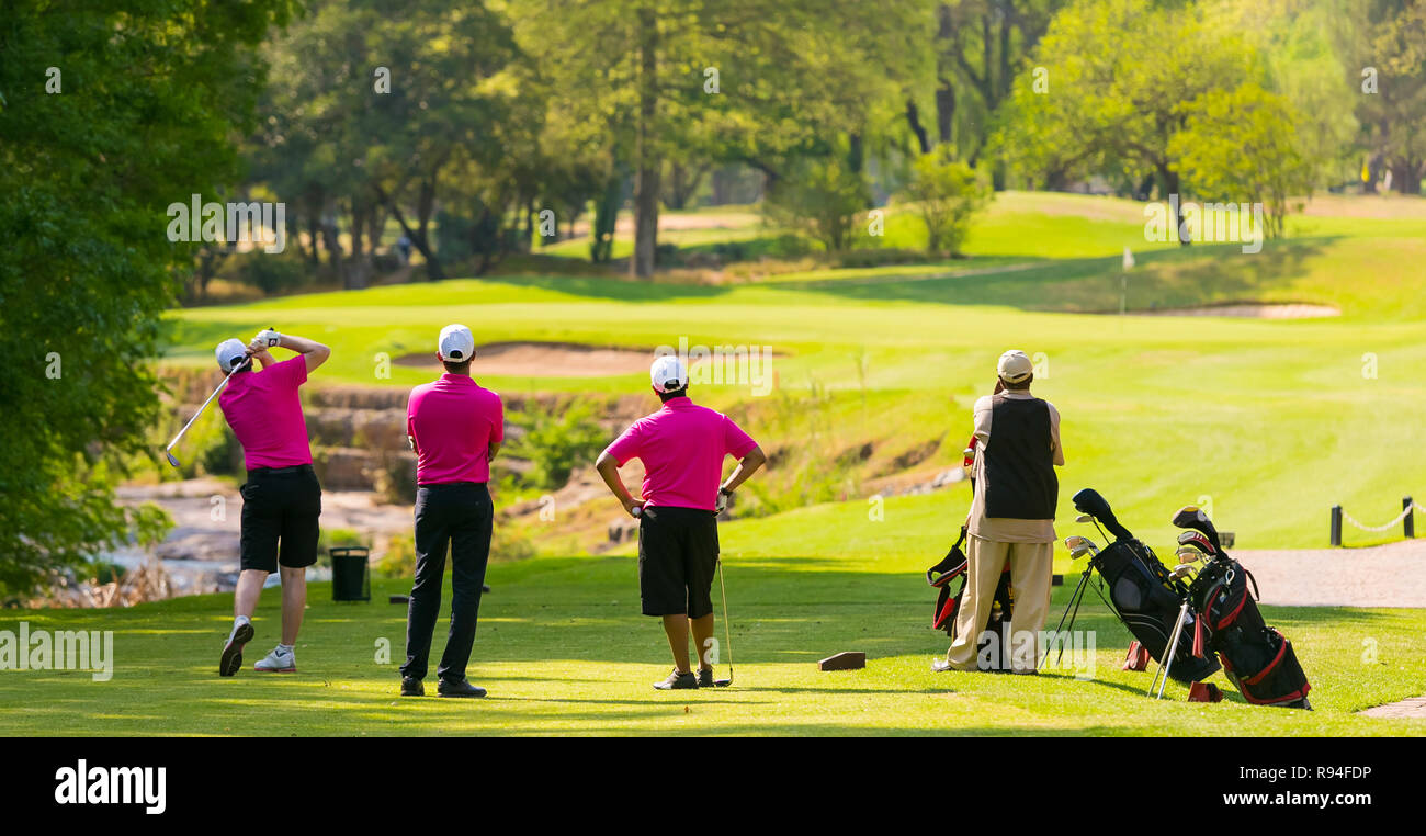 Group of golfers Tee off by a fairway on a sunny day Stock Photo