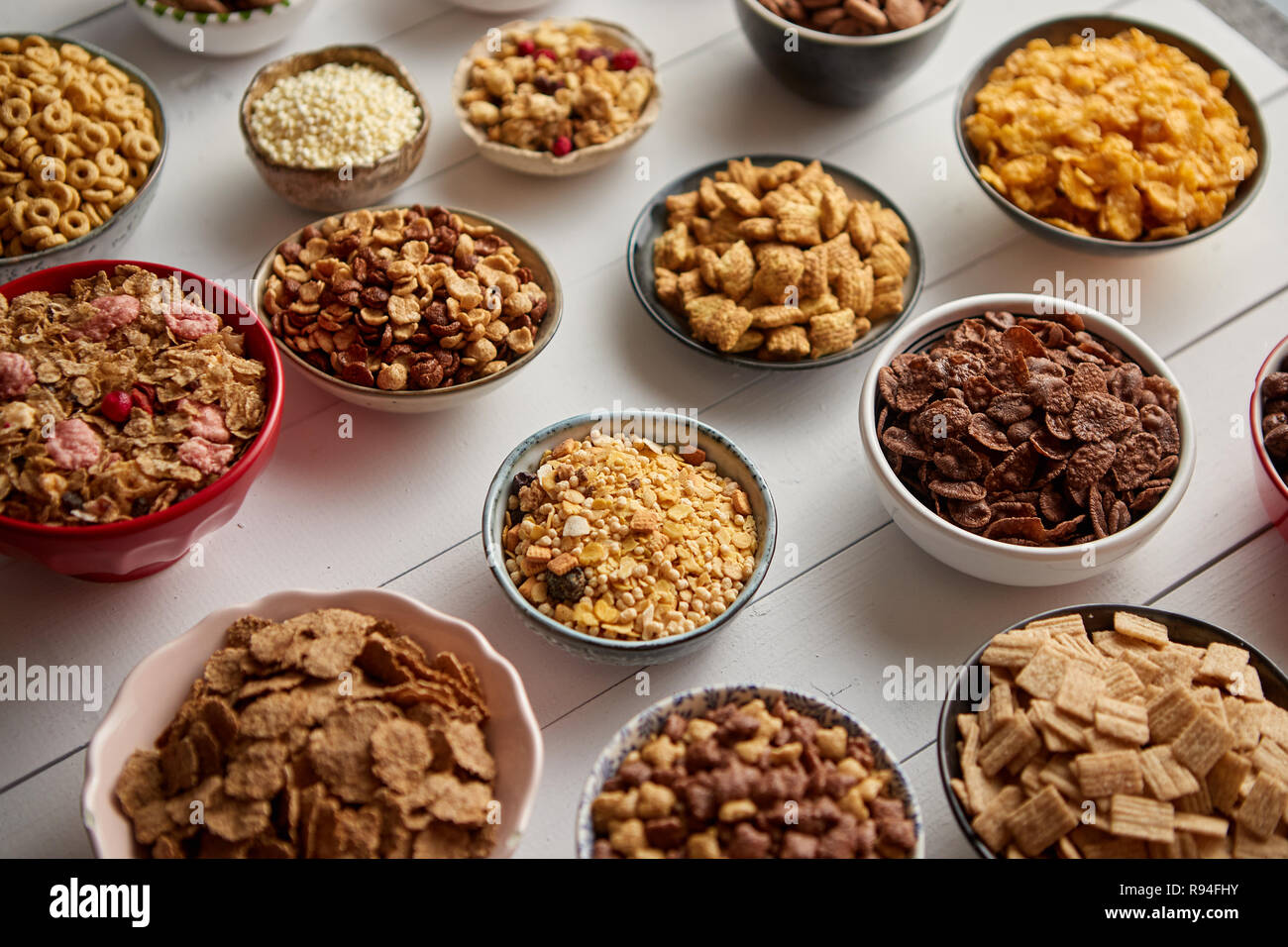 Assortment of different kinds cereals placed in ceramic bowls on table