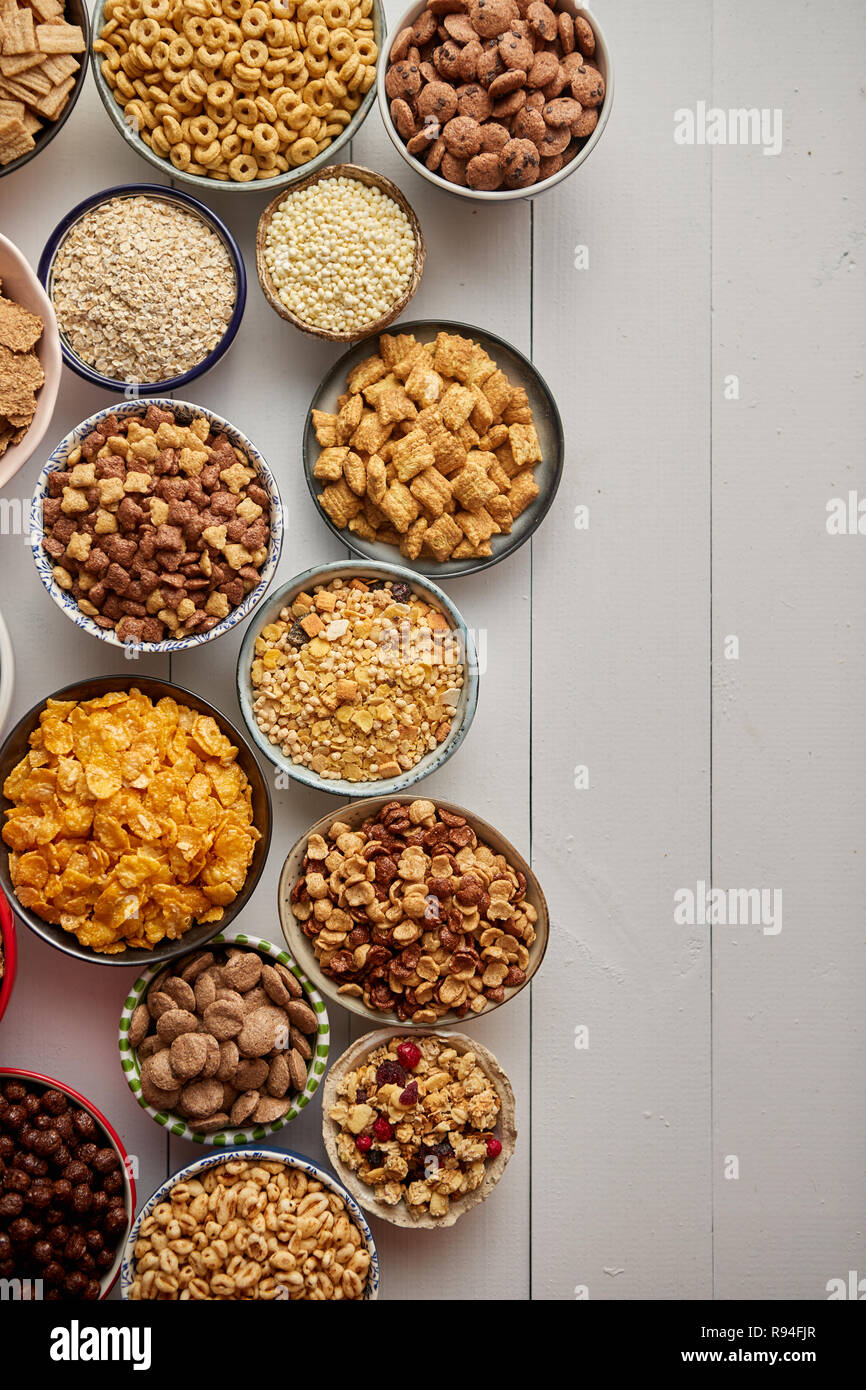 Assortment of different kinds cereals placed in ceramic bowls on table