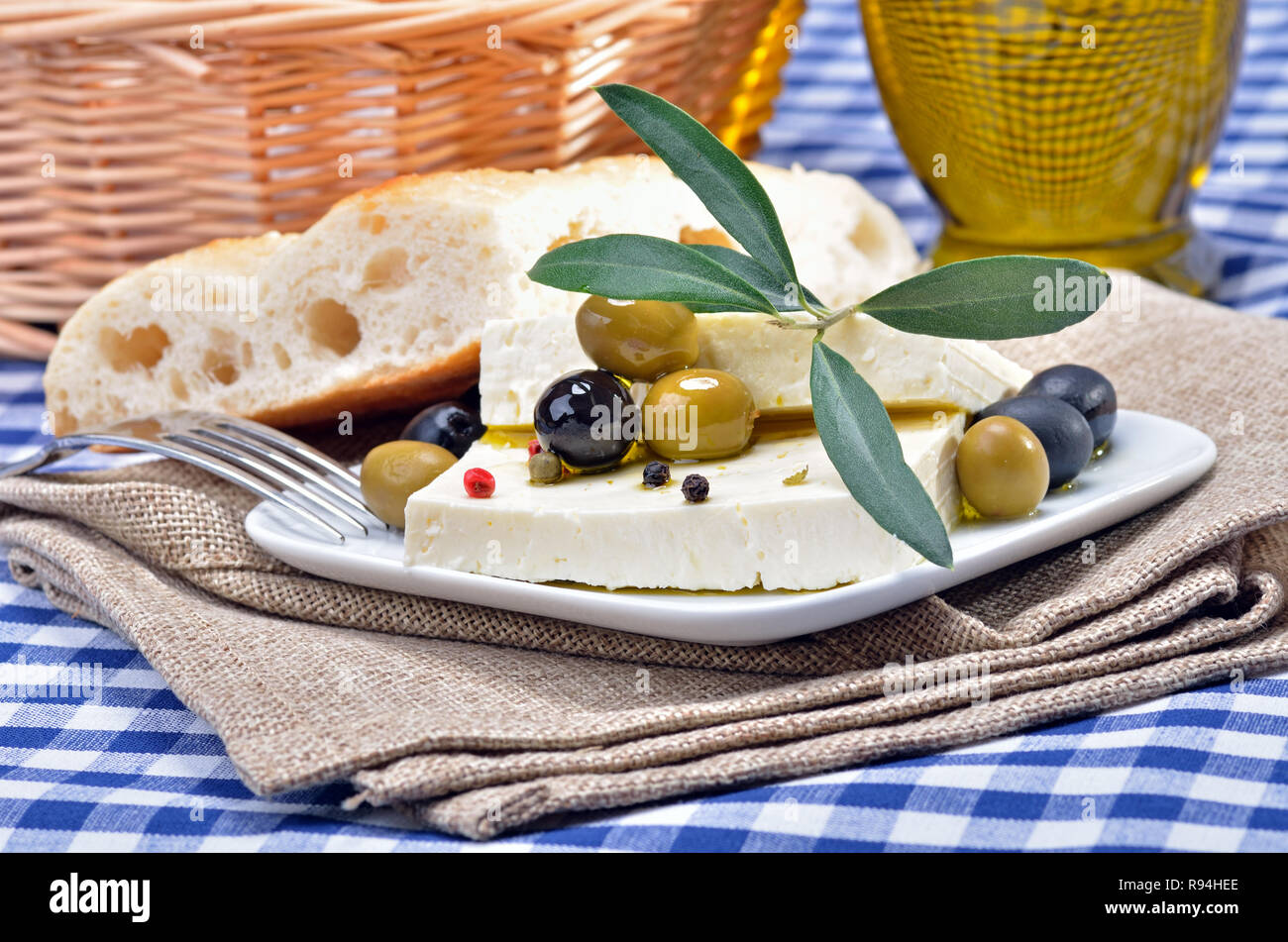 Greek feta cheese with flat bread and olives, decorated by olive leaves