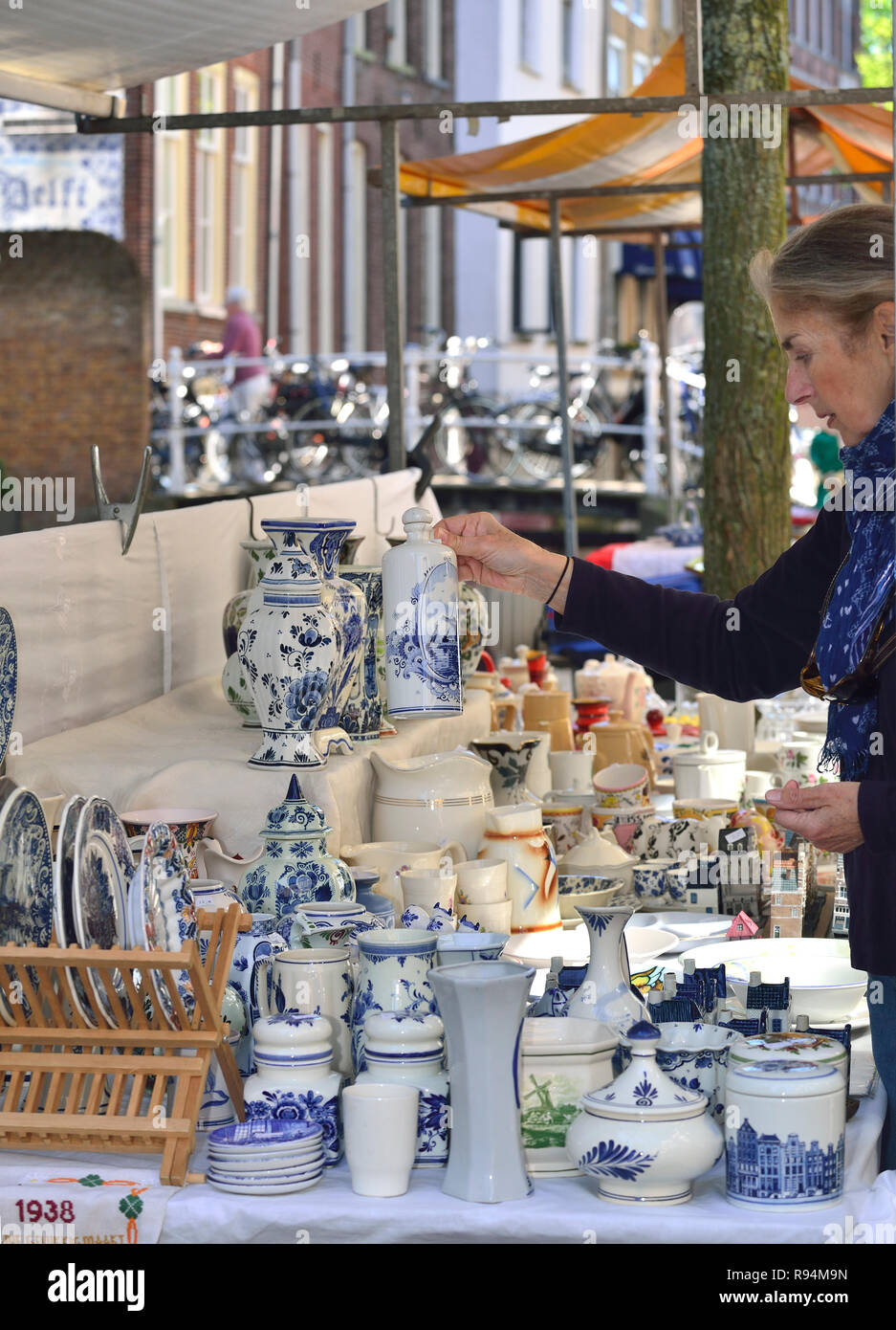 Female tourist looking at buying some Delftware at the Delft outdoor antique market, Holland, The Netherlands Stock Photo