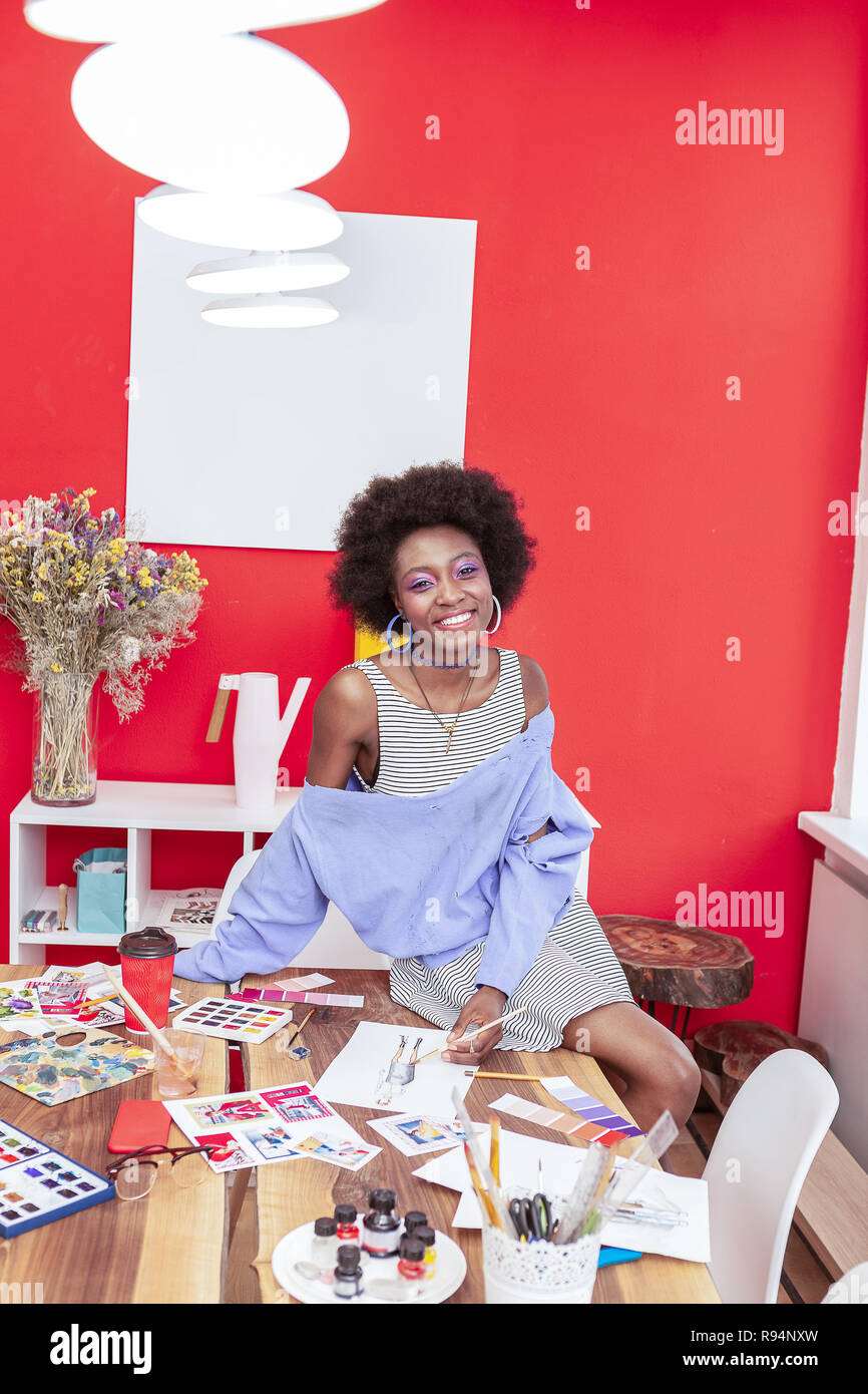 Smiling designer wearing massive earrings smiling broadly Stock Photo