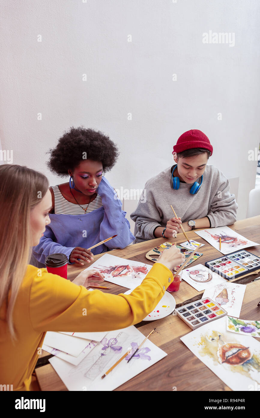Three fashionable art students attending drawing class Stock Photo