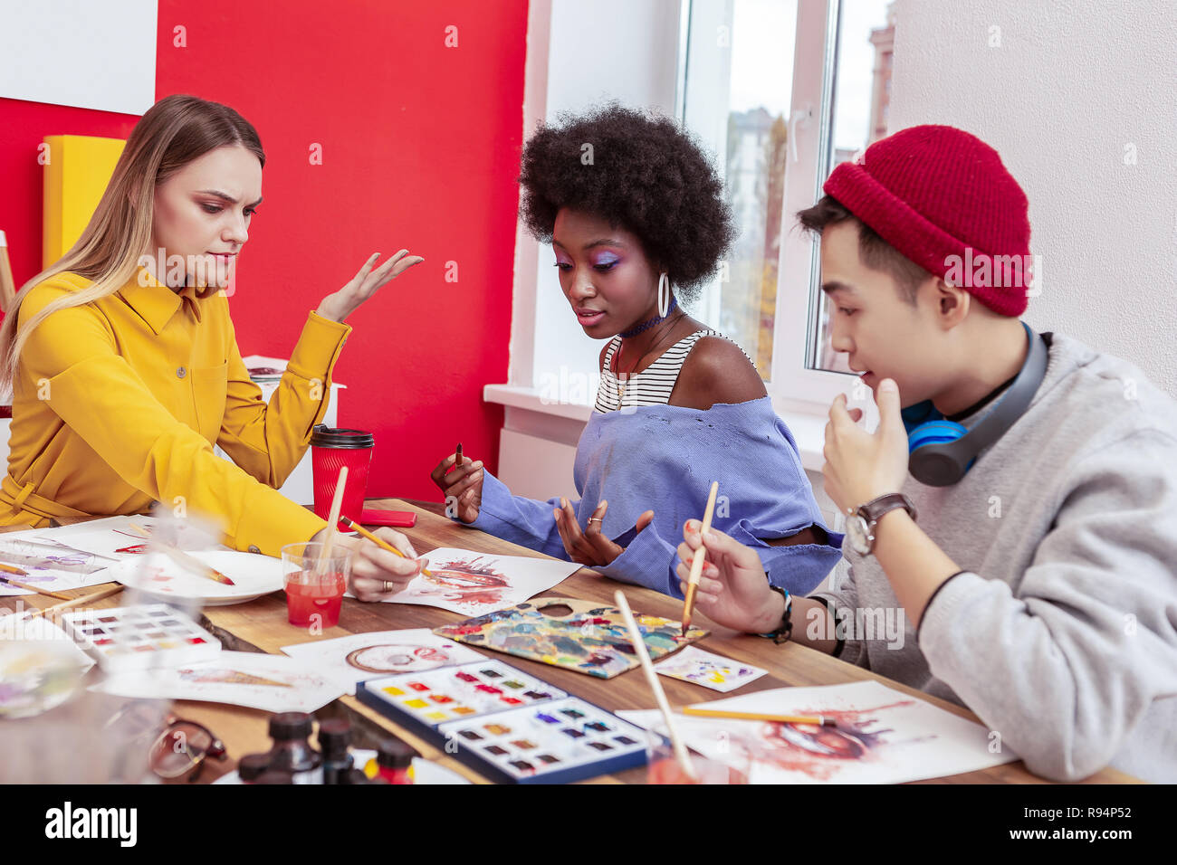 Three art students having some arguments while working together Stock Photo