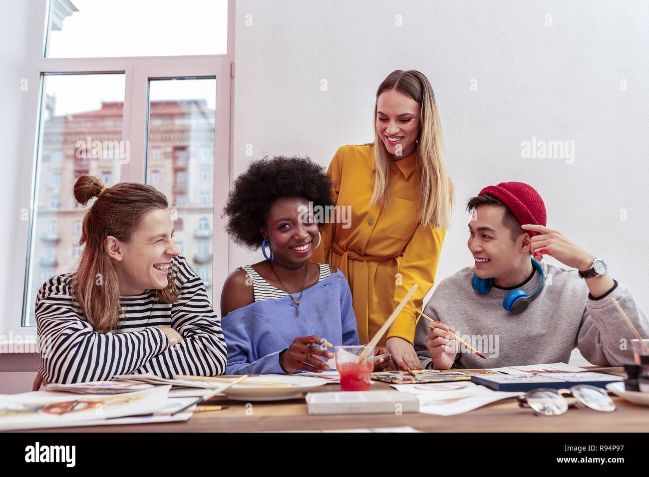 Cheerful trainees of fashion magazine enjoying working together Stock Photo