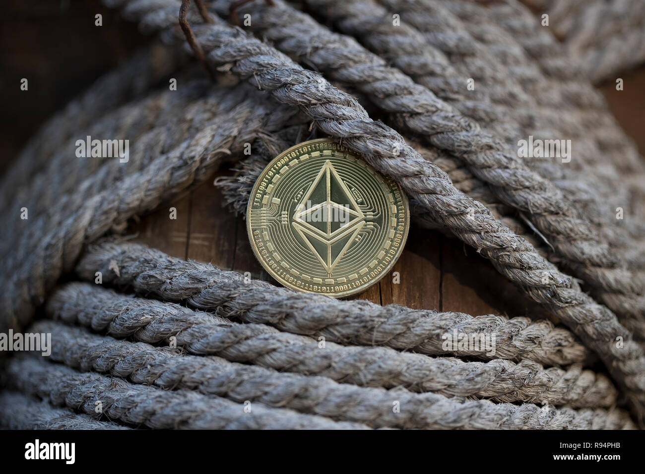 Ethereum cryptocurrency physical coin placed in between the ropes on ...