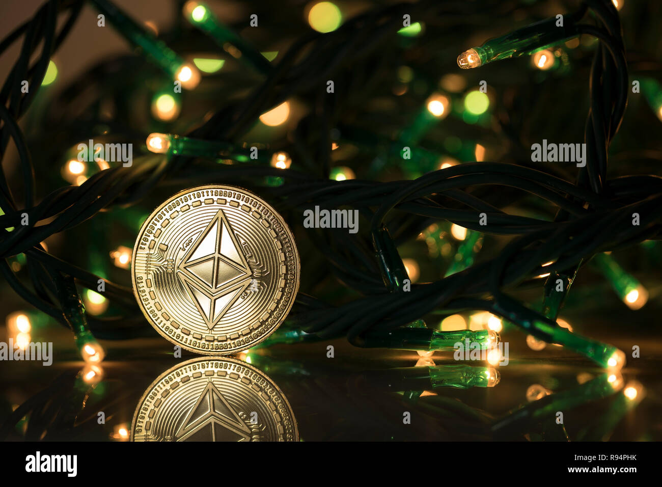 Ethereum classic physical coin surrounded with Christmas tree lights Stock Photo