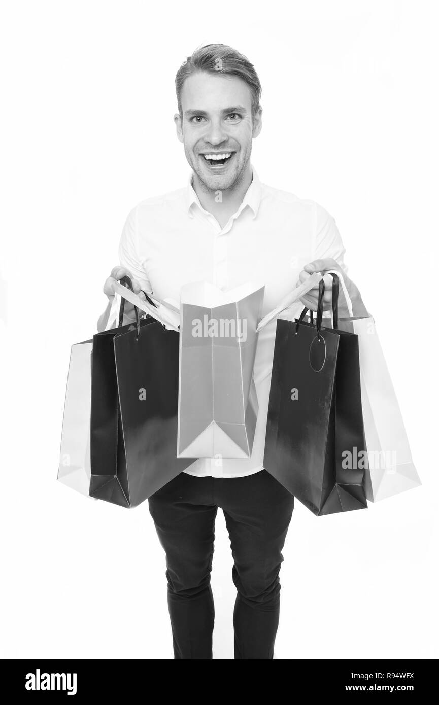 Man happy client received packages purchases. Delivery service. Guy buy fashionable clothes online. Online shopping concept. Man takes advantages online shopping. Guy carries bunch colorful bags. Stock Photo