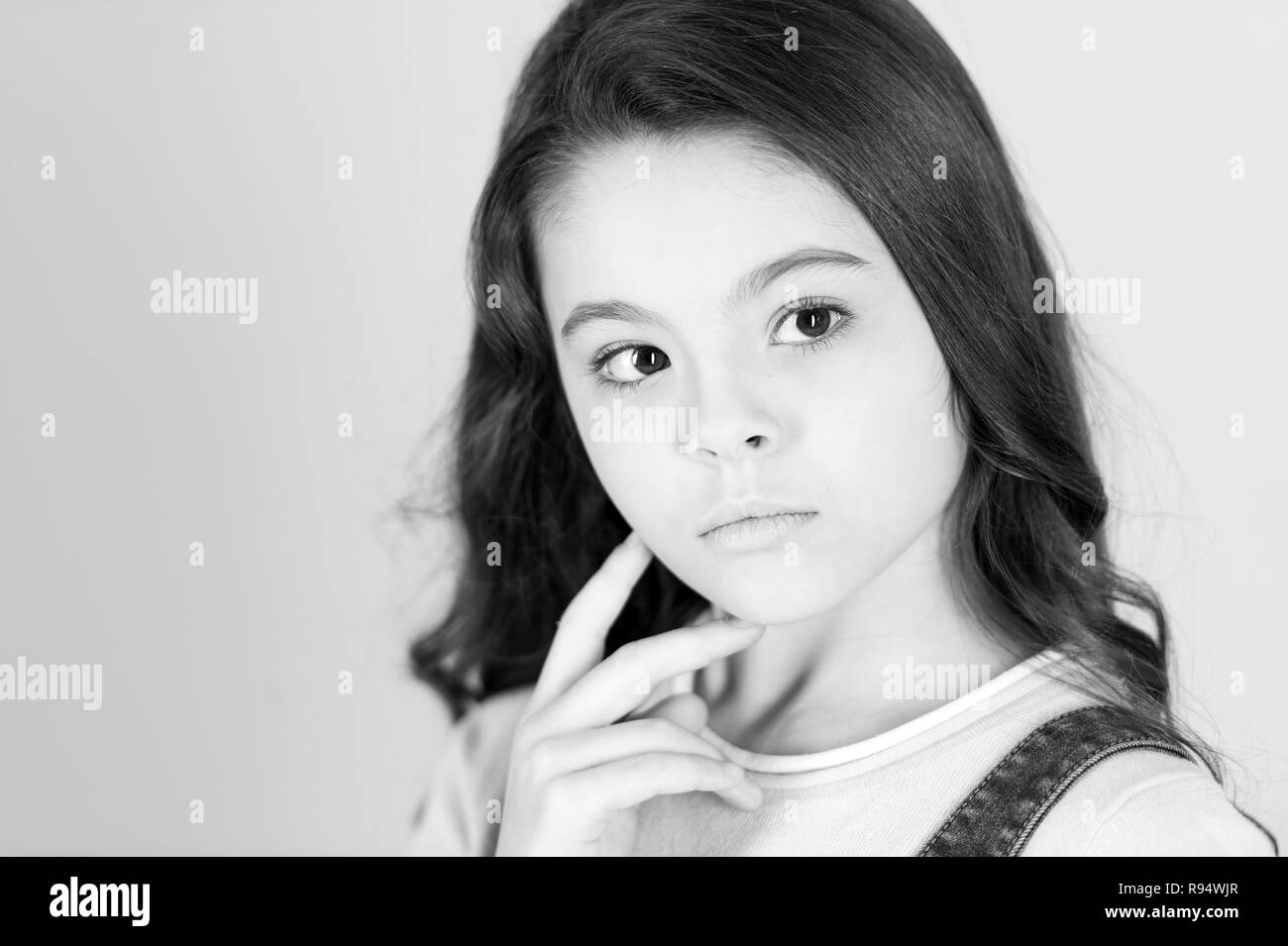 Beautiful little girl looking up and thinking Stock Photo - Alamy