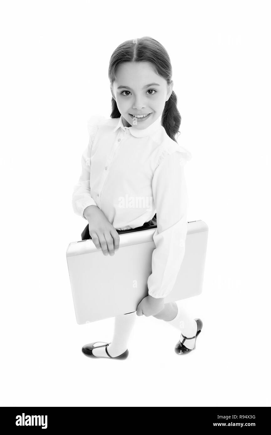 Modern technic education includes using laptop. Girl cute long curly hair isolated white background. Child girl school uniform clothes carries laptop. Child wear school uniform smart kid smiling face. Stock Photo