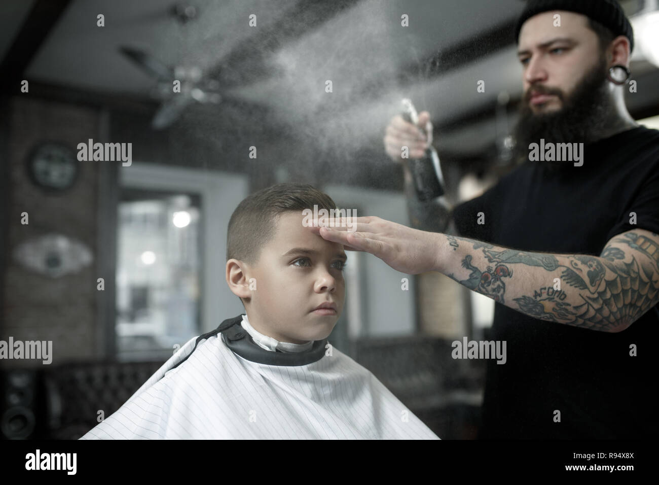 Children Hairdresser Cutting Little Boy Against A Dark Background