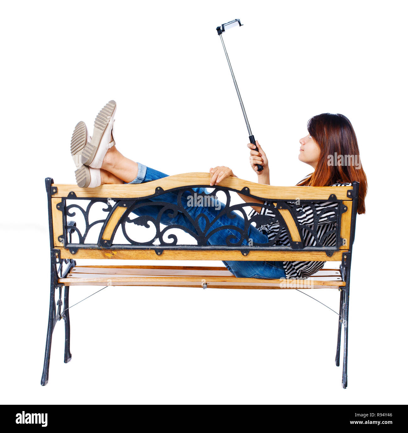 Back View Of A Woman To Make A Selfie Stick Portrait Sitting On