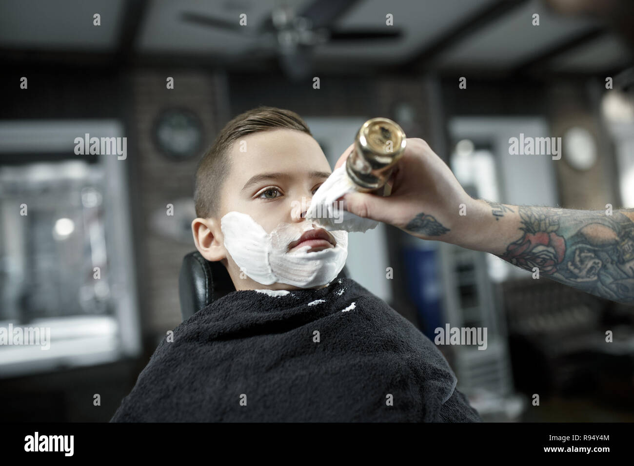 Children Hairdresser Cutting Little Boy Against A Dark Background