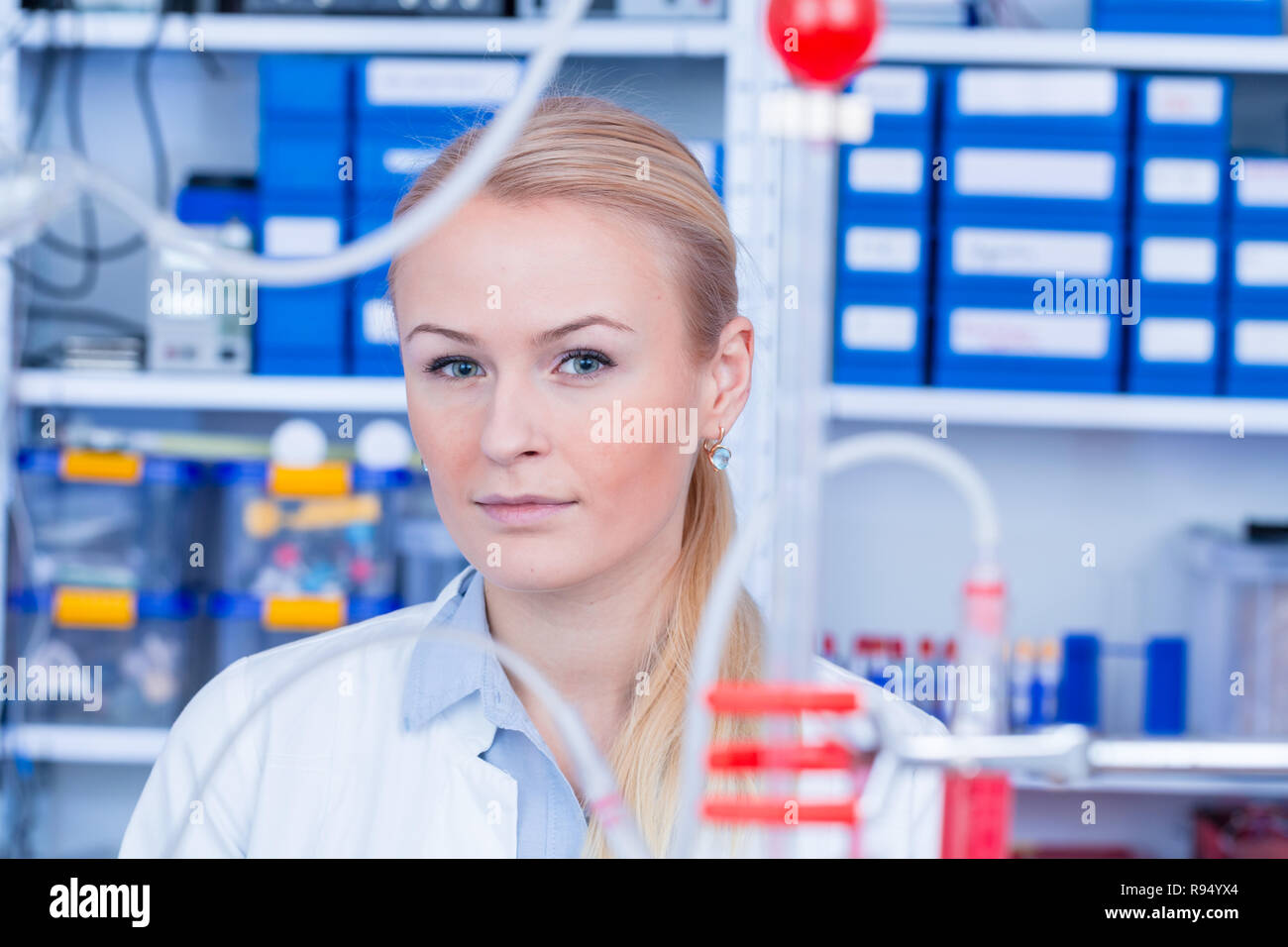 Female laboratory assistant with chemical experiment in scientific
