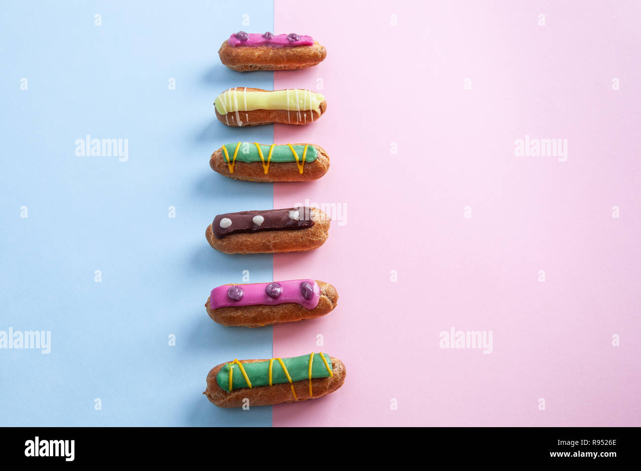 French eclairs on pink-blue background with copy space Stock Photo