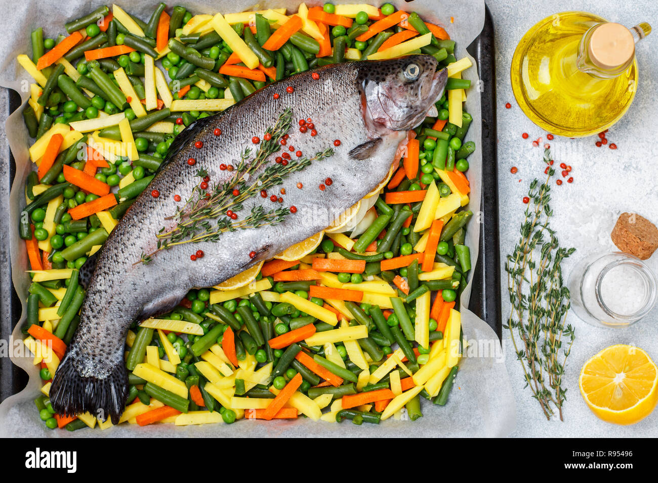 Raw fish trout with vegetables (potatoes, carrots, string beans, green