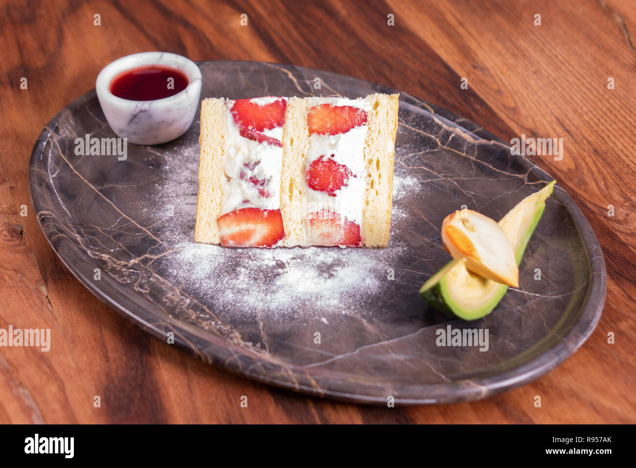 Strawberry cake in marble plate on wooden table Stock Photo