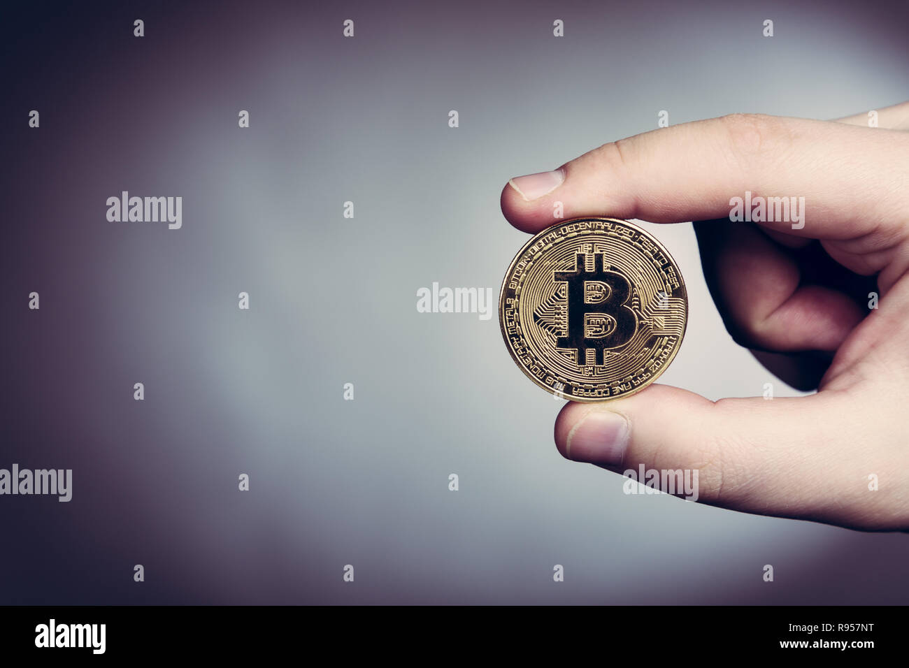Bitcoin cryptocurrency gold coin in man's hand Stock Photo