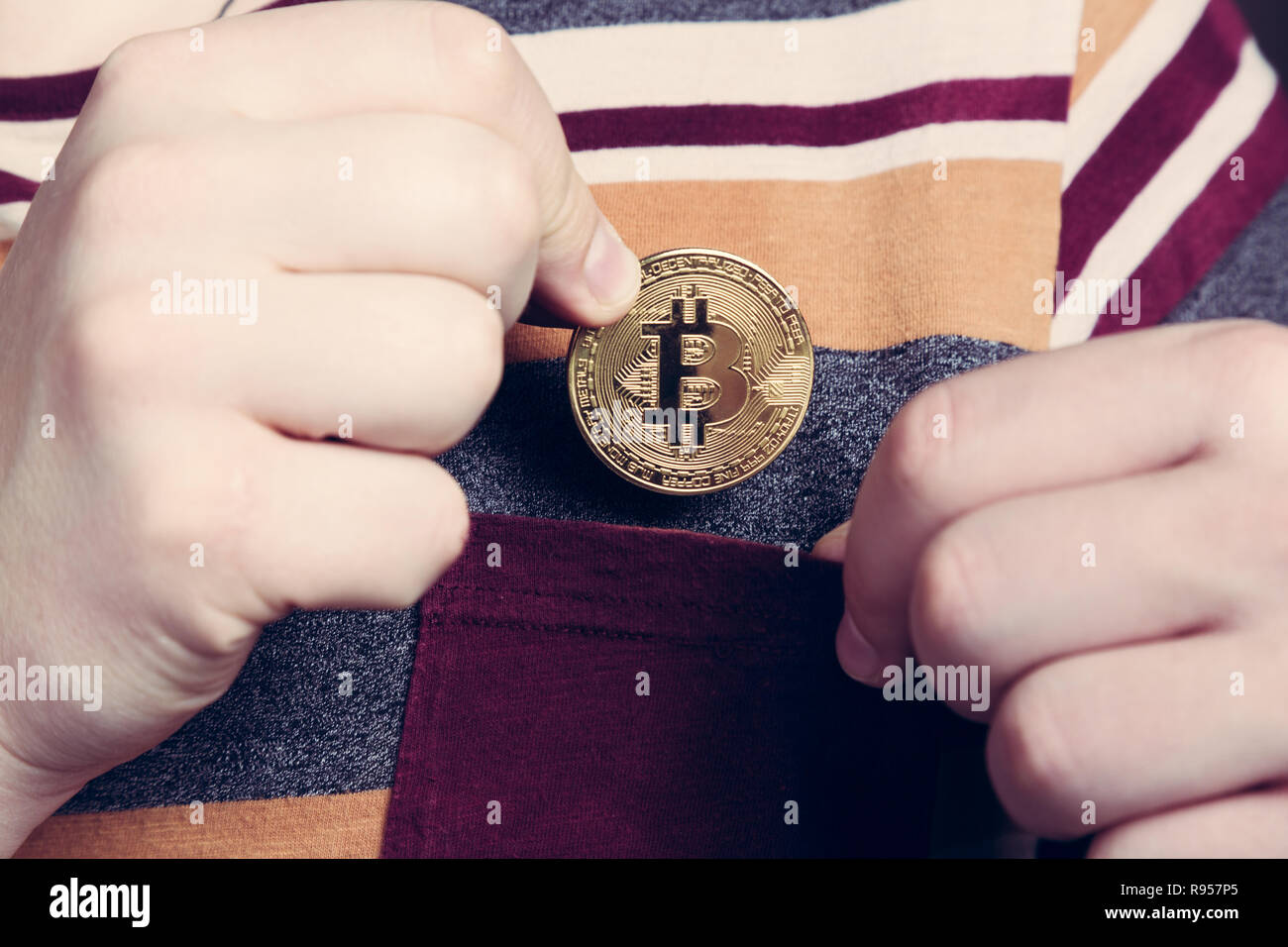 Putting bitcoin cryptocurrency coin into the pocket  Stock Photo
