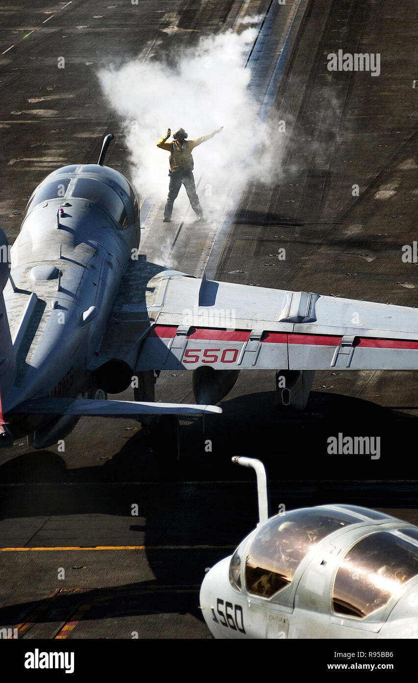 A U.S. Navy aircraft handler directs an EA-6B Prowler aircraft into launch position on the flight deck of the USS Ronald Reagan (CVN 76). DoD photo by Petty Officer 2nd Class Aaron Burden, U.S. Navy Stock Photo