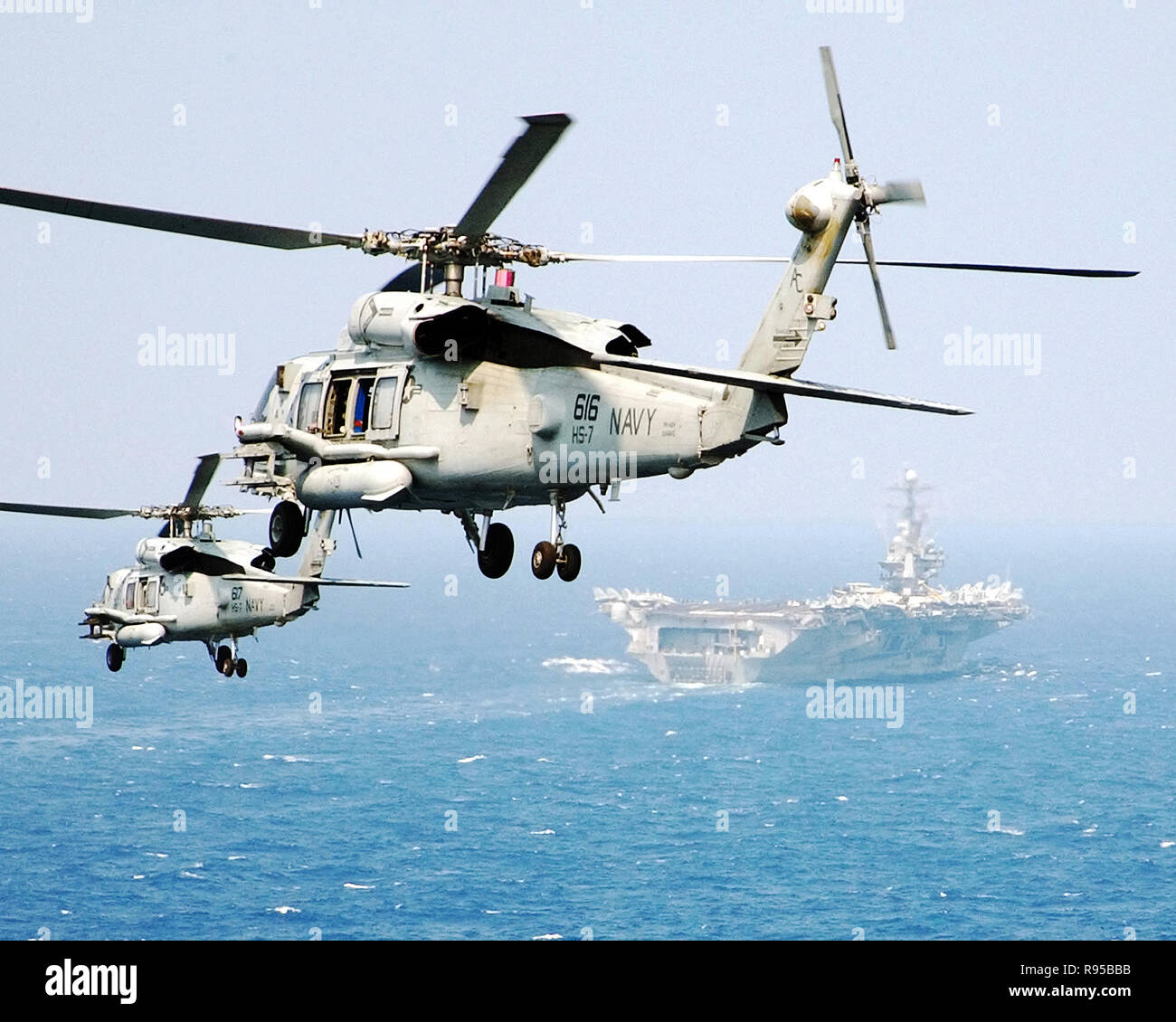 Two HH-60H Seahawk helicopters assigned to the 'Dusty Dogs' of Helicopter Anti-Submarine Squadron Seven (HS-7), prepare to land on the flight deck of the Nimitz-class aircraft carrier USS Harry S. Truman (CVN 75).U.S. Navy photo by Photographer's Mate Airman Ryan O'Connor Stock Photo