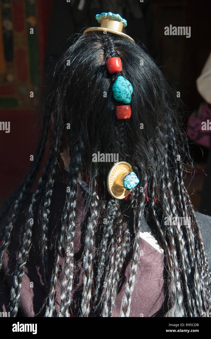 Woman displaying her hair adornments and jewellery on an outing to the Norbulingka Summer Palace, Lhasa, Tibet, China Stock Photo