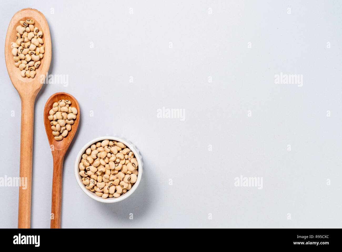 Wooden spoon and pot with black beans. Background with space for text ...