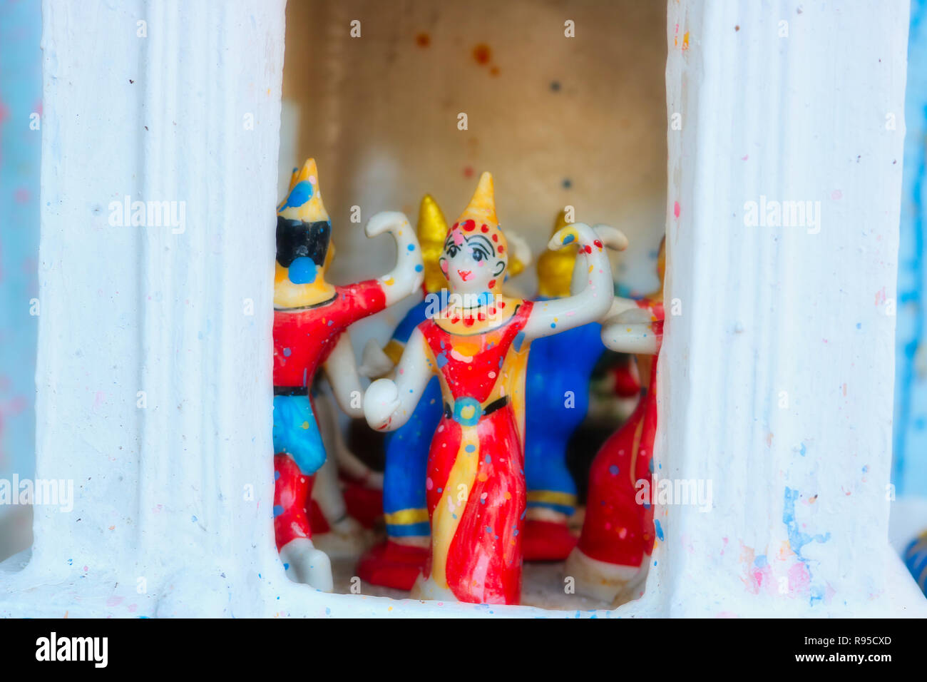 This photo shows a look into a small Buddhist temple in Thailand where beautiful ceramic figures are dancing Stock Photo