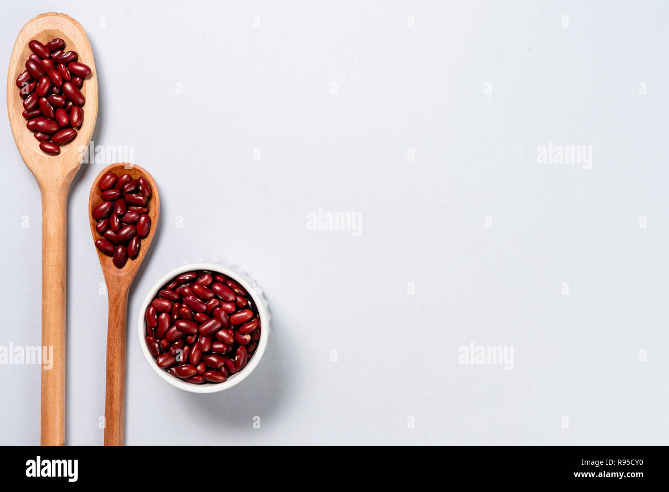 Wooden spoon and pot with purple beans. Background with space for text ...