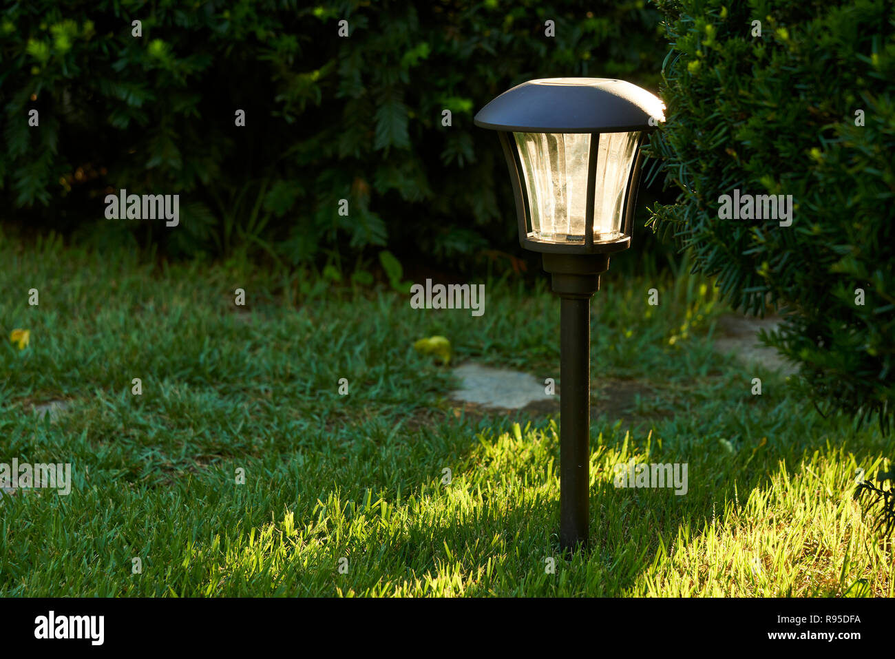 sunlight and solar lights for outdoor pathway in a garden Stock Photo