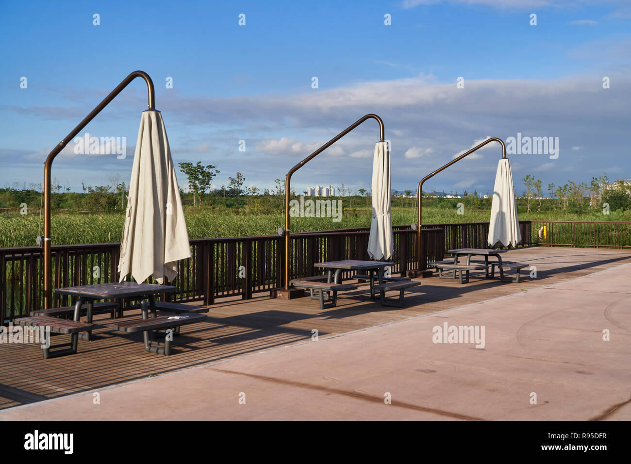 table and patio round offset cantilever umbrella garden parasol in a park Stock Photo