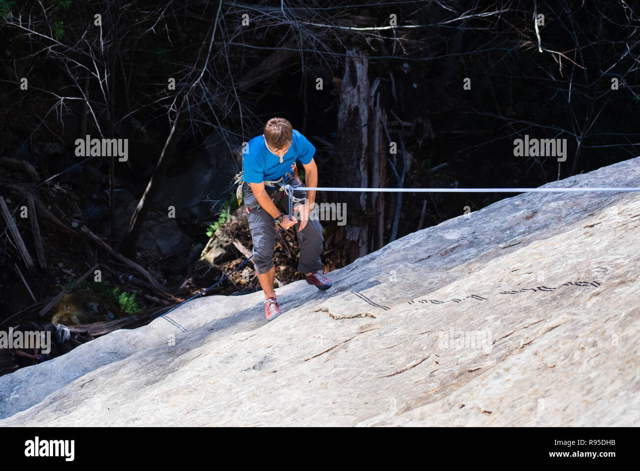 February 11, 2018 Los Gatos / CA / USA - Climber rappelling after climbing a rock wall at the waterfall in Castle Rock State Park, Santa Cruz mountain Stock Photo