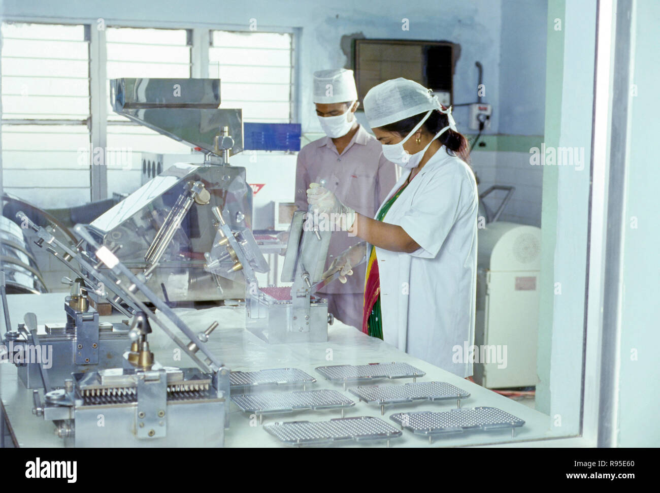 woman and man Examine medicine, Pharmaceutical Plant, capsule section Stock Photo