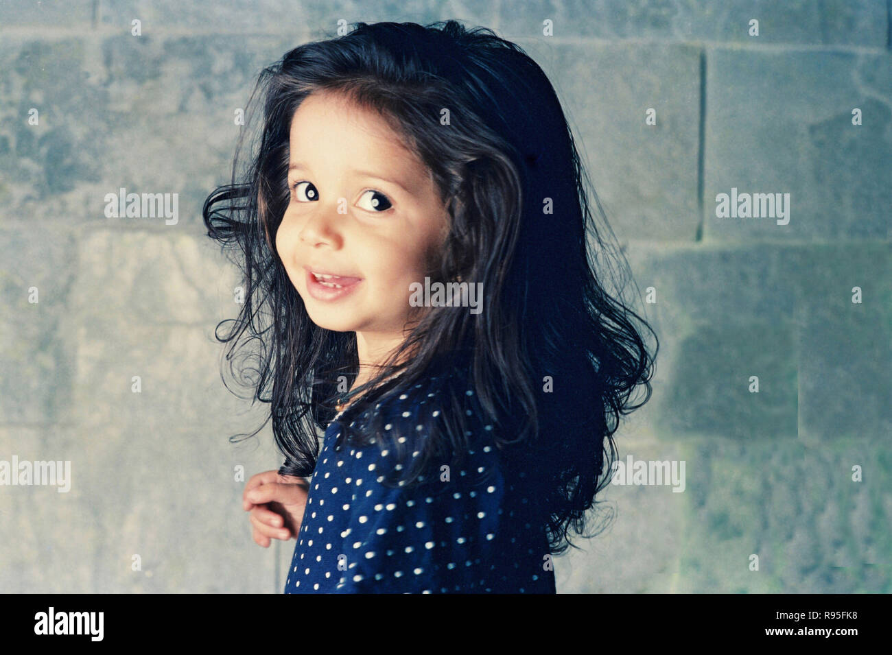 Baby girl small child wearing blue polka dot dress Stock Photo