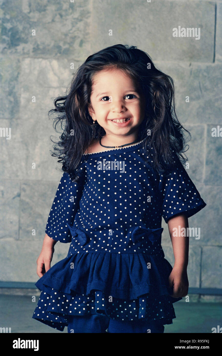 Baby girl small child wearing blue polka dot frock Stock Photo