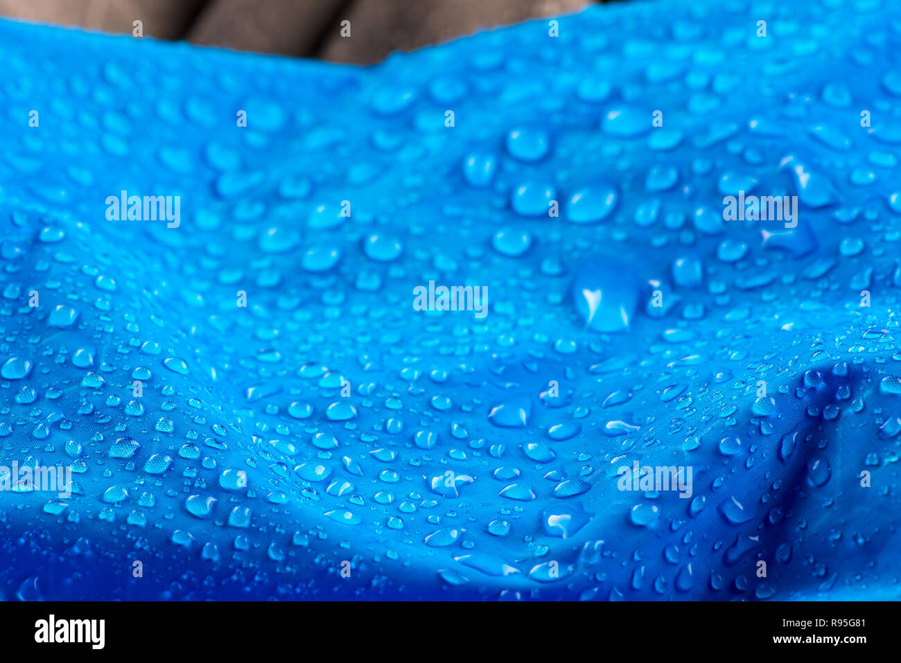 Nylon waterproof fabric with blurred background. Rain Drops on Water